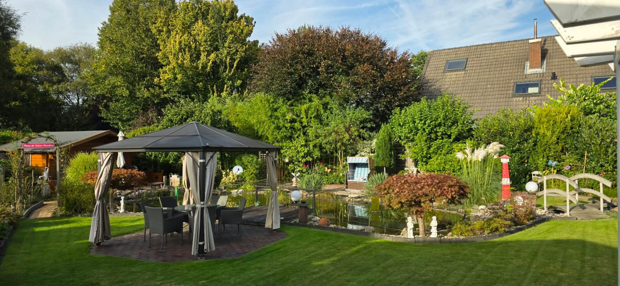 Garten mit Pavillon, Teich und Strandkorb an der Ferienwohnung Wiesmoor